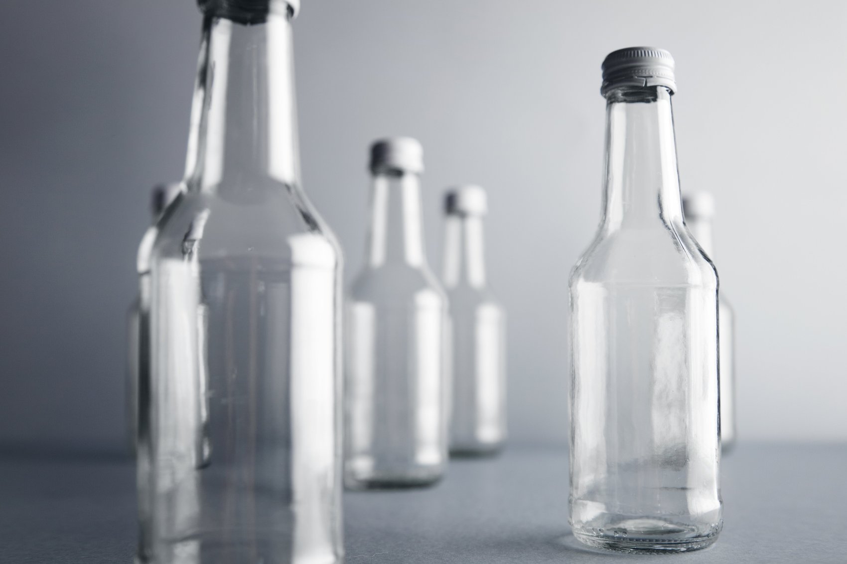 close-view-clear-unlabeled-empty-glass-bottles-cold-beverages-drinks